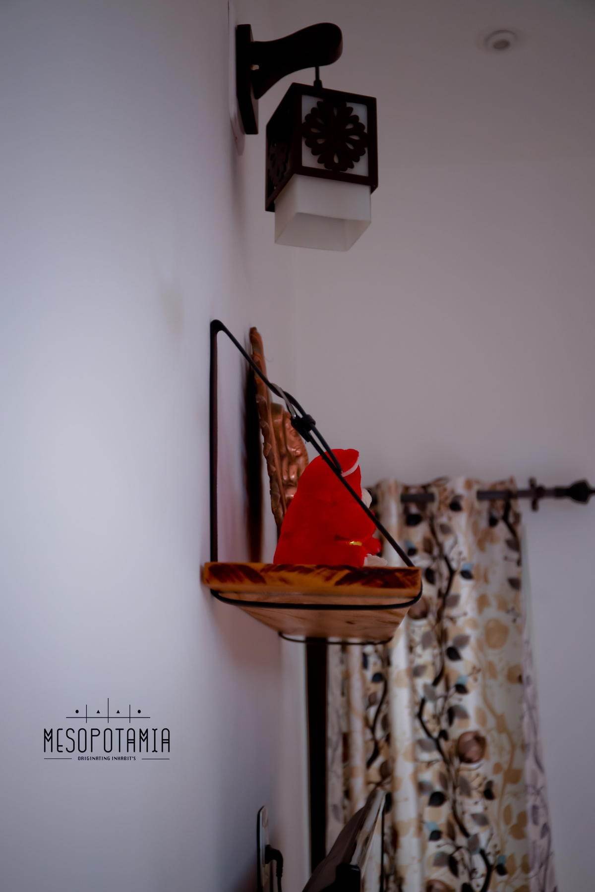 A corner shelf and a hanging lamp against a plain wall