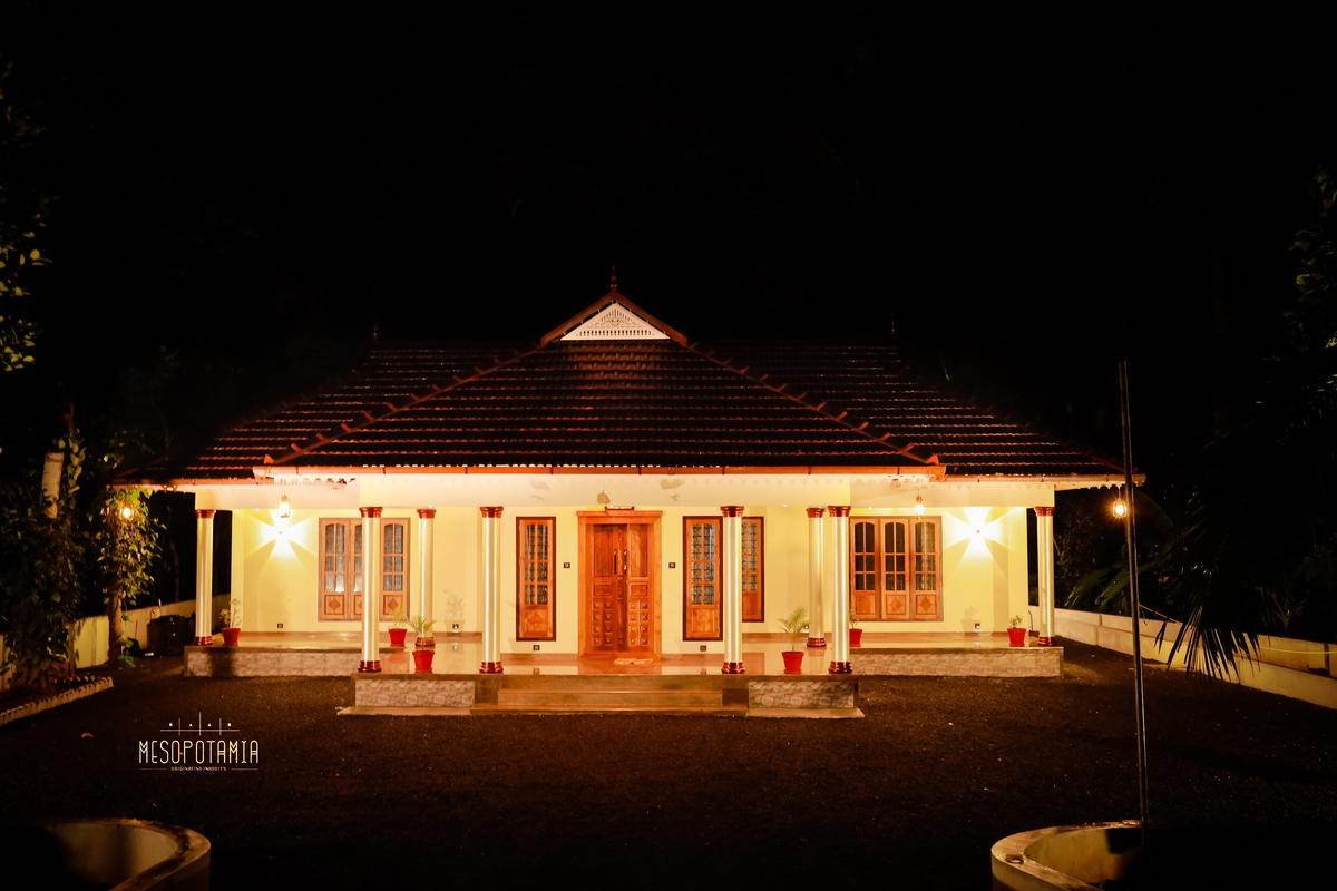 A pitched, tiled house lit from within at night